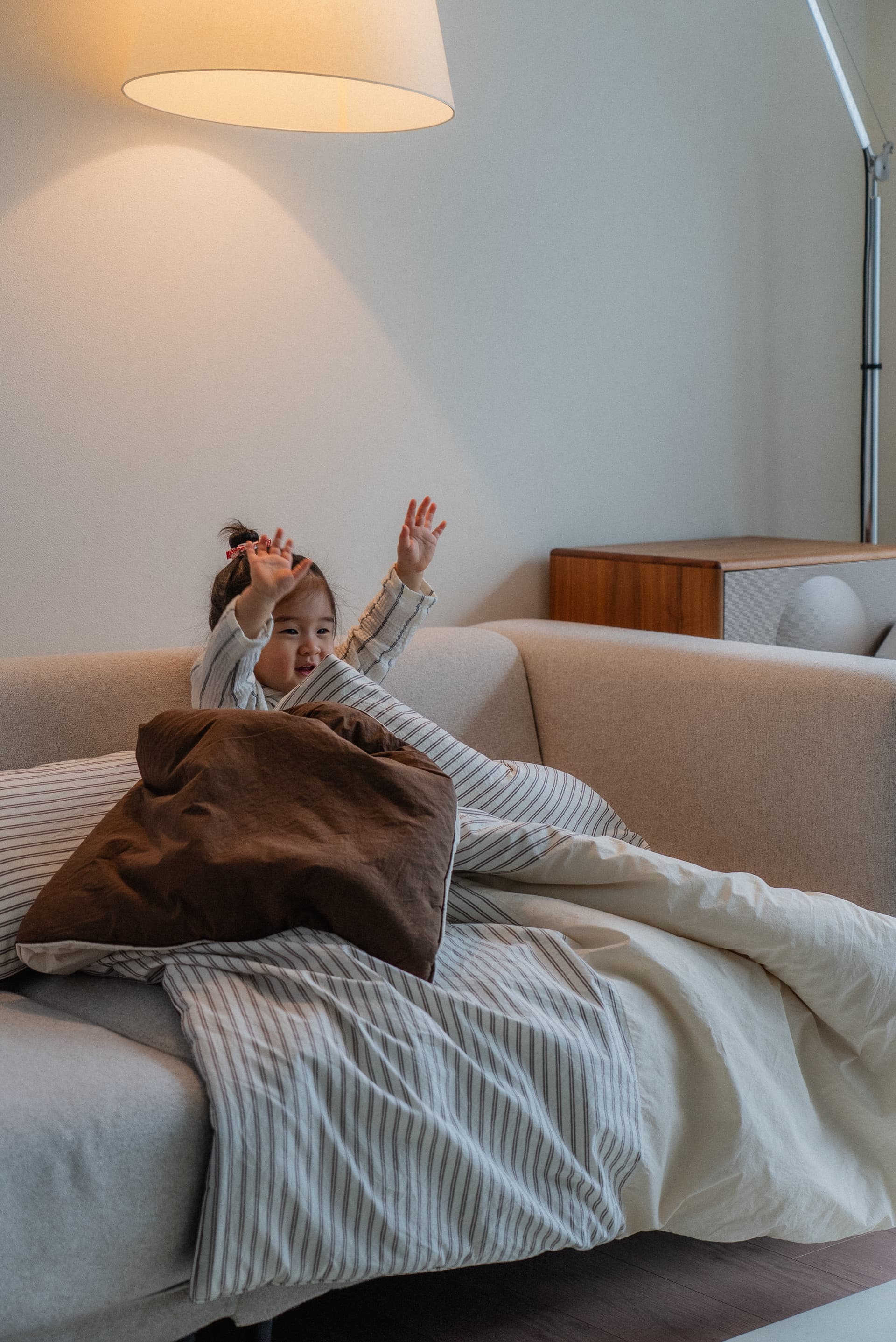 Warm, cozy striped bedding arranged on a soft sofa